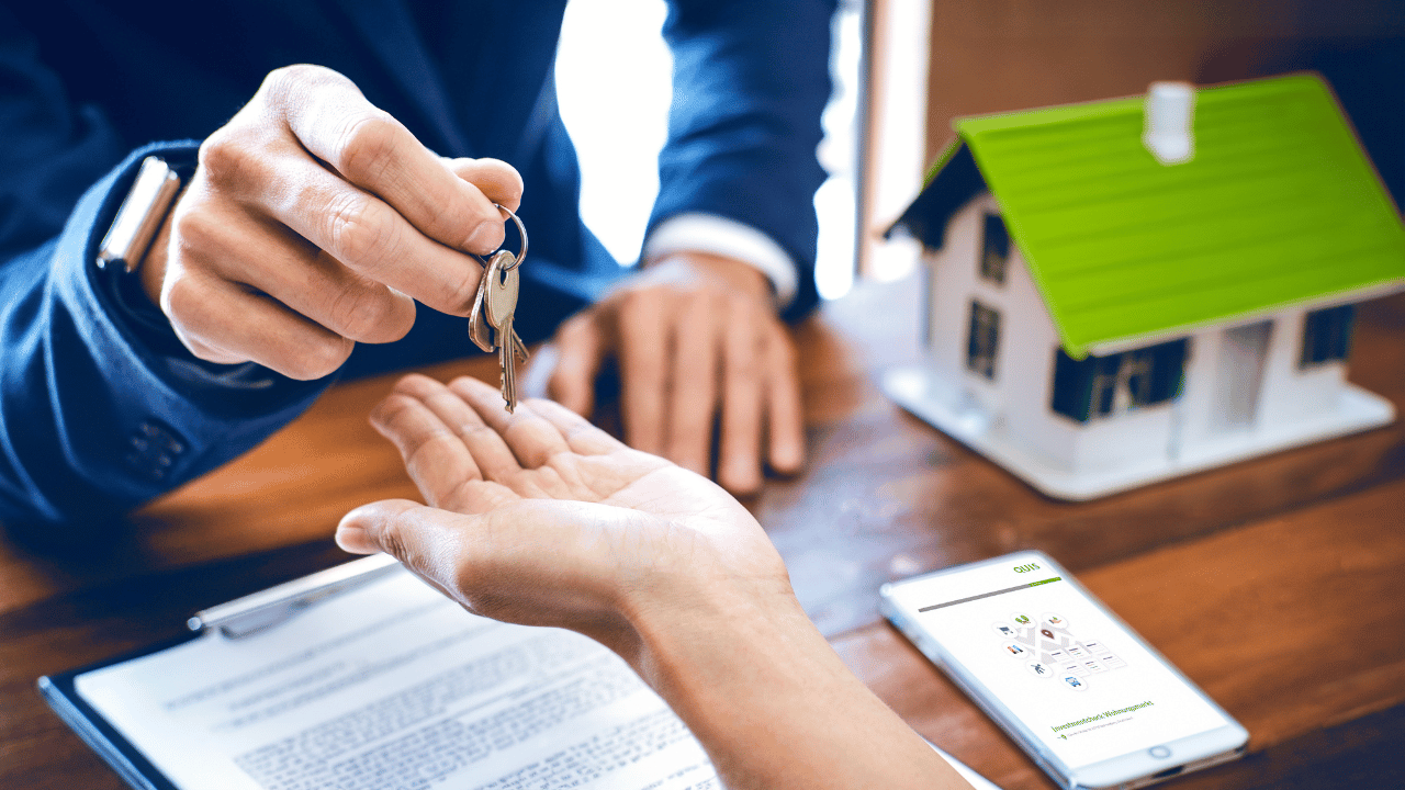 Ein Immobilienmakler gibt seinem Kunden den Schlüssel zum Haus