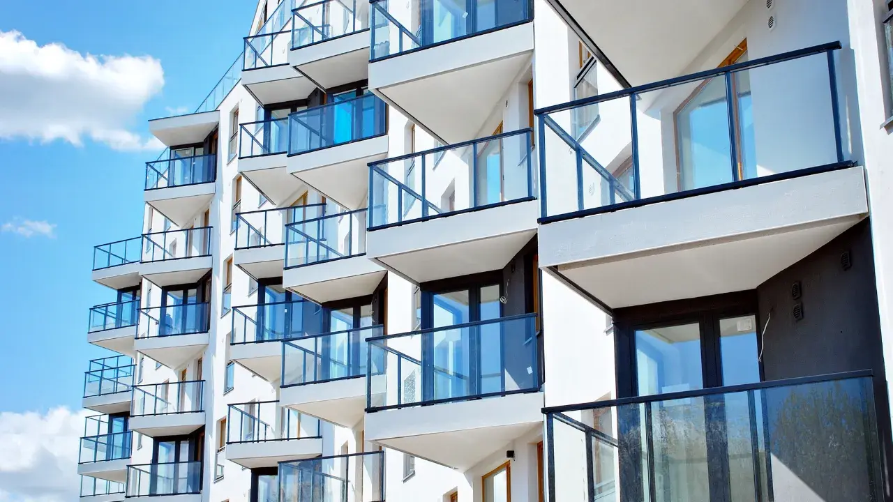 Clusterwohnungen in einem modernen Gebäude mit Glasgeländern an den Balkonen, passend für gemeinschaftliches Wohnen.