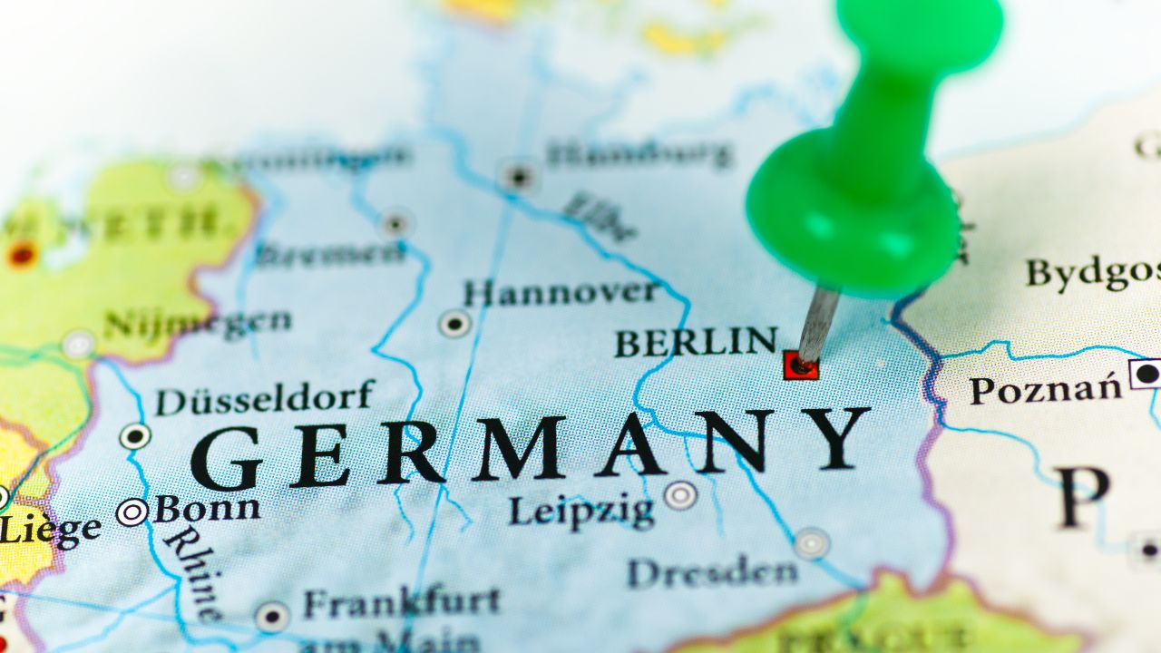 Nahaufnahme einer Landkarte von Deutschland mit einer grünen Reißzwecke, die Berlin markiert.